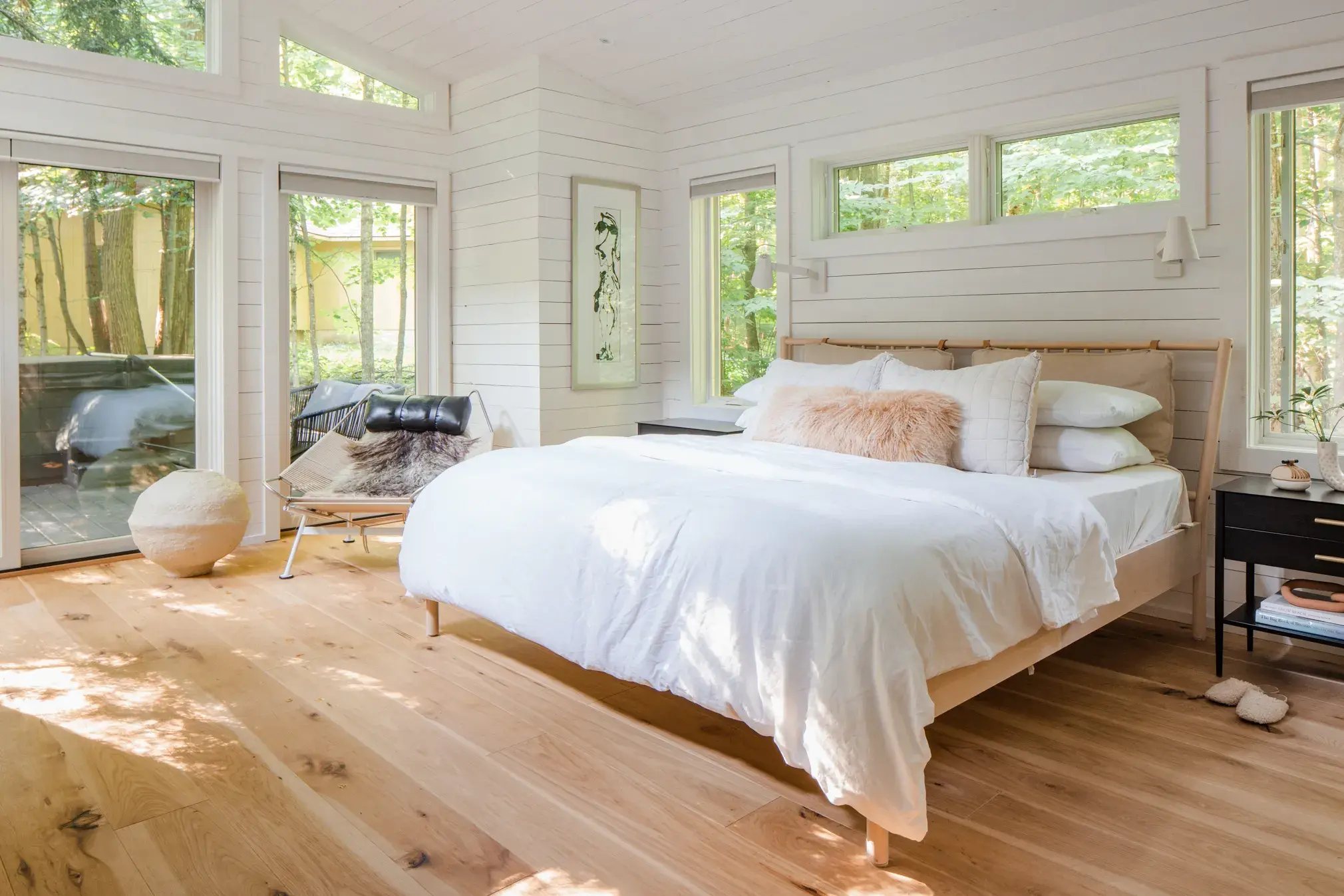 Bright master bedroom with large windows and a comfortable bed
